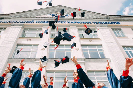 university students throwing their graduation caps in the air