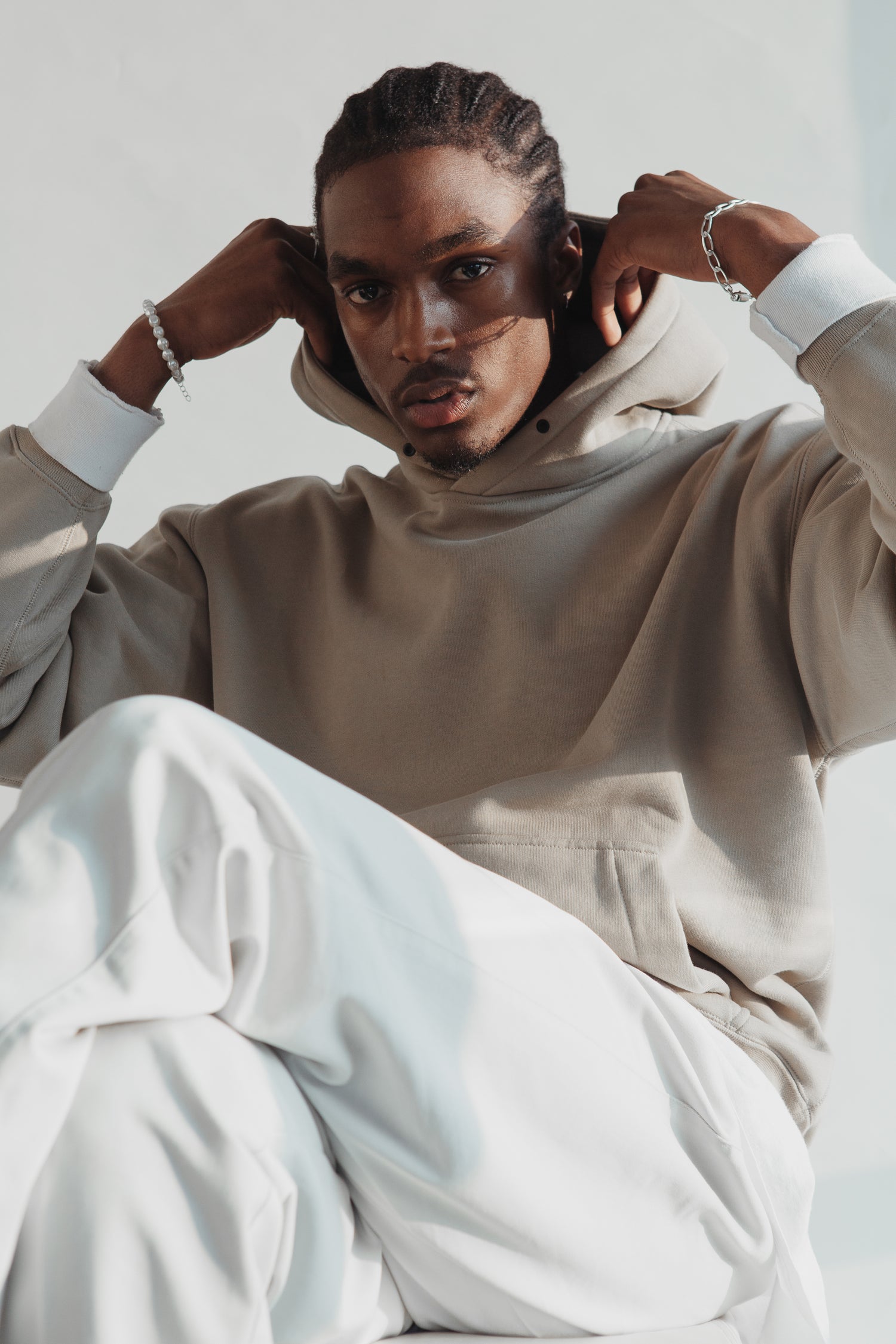 man sitting down in a white and tan outfit